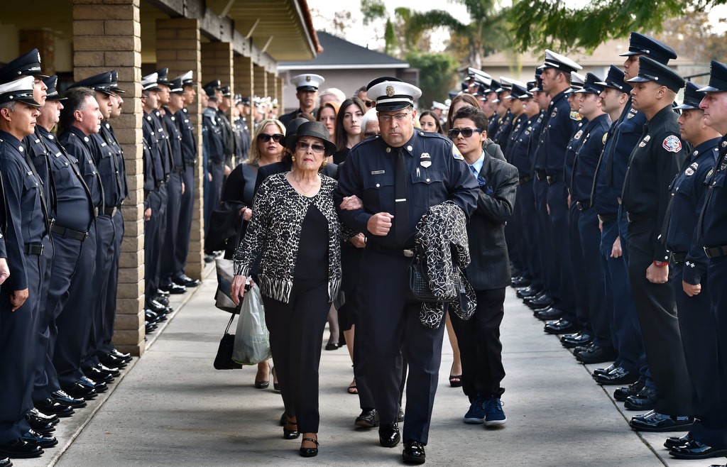 Esperanza Castro, mother of Santa Ana/OCFA Firefighter Ron Castro, is escorted to the church by Stephen Horner for Ron’s memorial service at Calvary Chapel in Santa Ana. Photo by Steven Georges/Behind the Badge OC