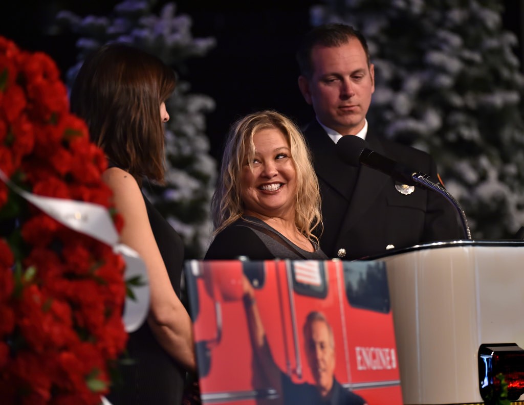 Daughter Jennifer Mercer, son Brandon Castro and daughter in law Jaymie Castro share a happy moment about Santa Ana/OCFA Firefighter Ron Castro during a memorial service for Ron at Calvary Chapel in Santa Ana. Photo by Steven Georges/Behind the Badge OC