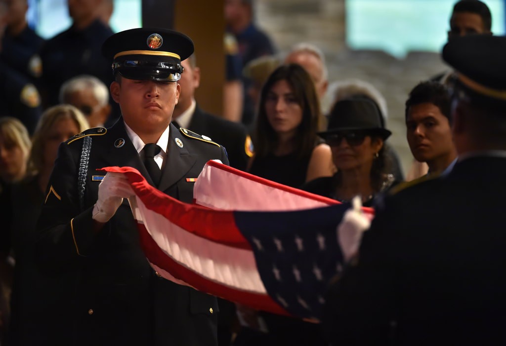 A US Army Honor Guards help fold an American flag to be presented to Santa Ana/OCFA Firefighter Ron Castro’s wife. Photo by Steven Georges/Behind the Badge OC