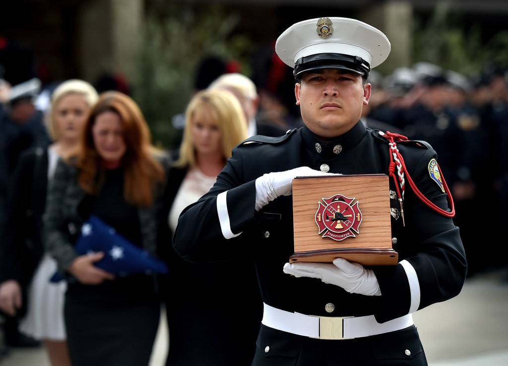 An OCFA Honor Guard caries the ashes of Santa Ana/OCFA Firefighter Ron Castro from the church with Ron’s family behind him at the conclusion of a memorial service for him. Photo by Steven Georges/Behind the Badge OC