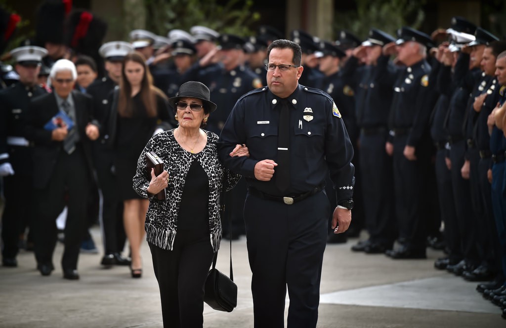 Esperanza Castro, mother of Santa Ana/OCFA Firefighter Ron Castro, is escorted from the church by Stephen Horner at the conclusion of Ron’s memorial service at Calvary Chapel in Santa Ana. Photo by Steven Georges/Behind the Badge OC