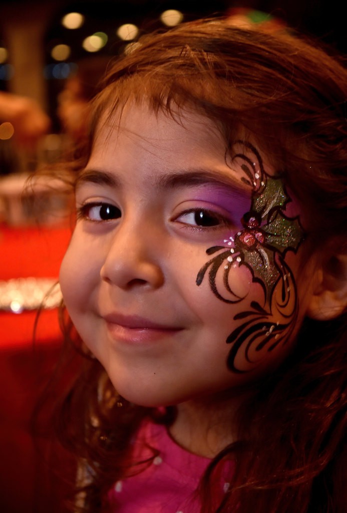 Five-year-old Savannah Hernandez shows off the face painting work of art she received during the Make A Wish Holiday Harbor Cruise. Photo by Steven Georges/Behind the Badge OC
