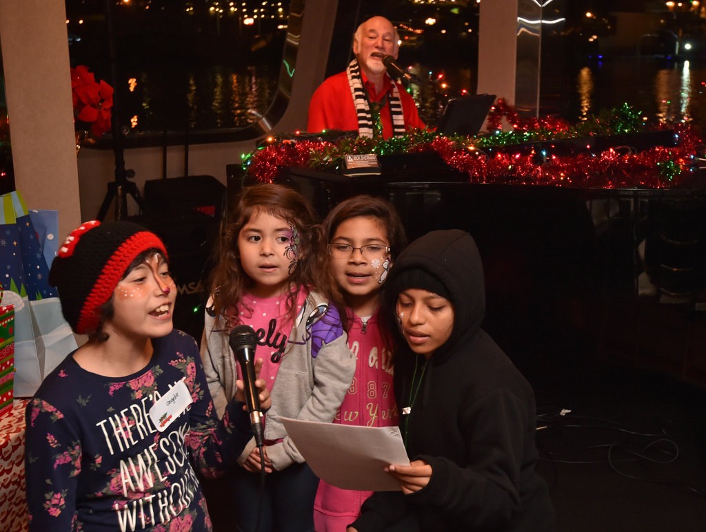 Rich Sherman plays christmas songs as kids sing during the Make A Wish Holiday Harbor Cruise. Photo by Steven Georges/Behind the Badge OC