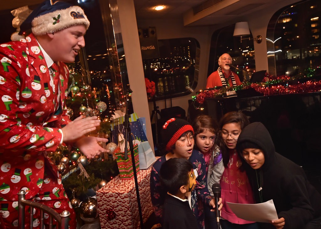 Max Werderman, left, and piano player Rich Sherman sing Christmas songs with the kids during the Make A Wish Holiday Harbor Cruise. Photo by Steven Georges/Behind the Badge OC