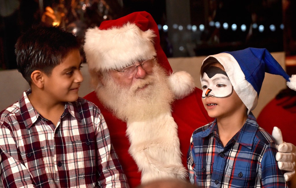 Angel Barrios, 7, left, and his brother Isaac Darrios, 6, get a visit with Santa during the Make A Wish Holiday Harbor Cruise. Photo by Steven Georges/Behind the Badge OC