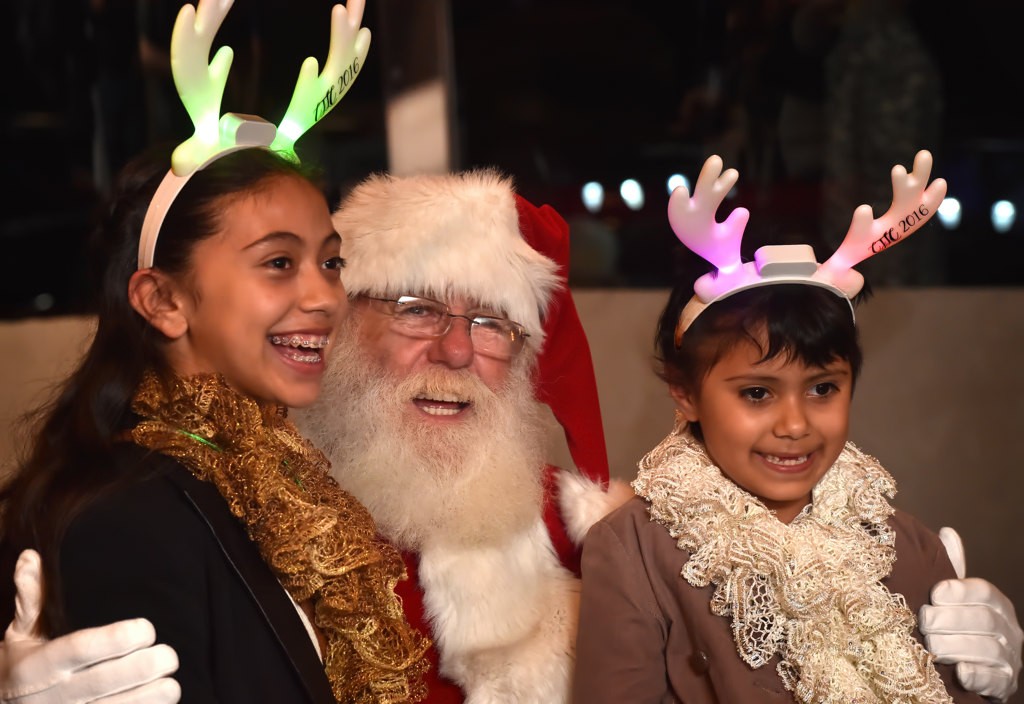 Brinda Sanchez, 12, and her sister Arinna Sanchez, 7, of Garden Grove flash a big smile with Santa. Photo by Steven Georges/Behind the Badge OC