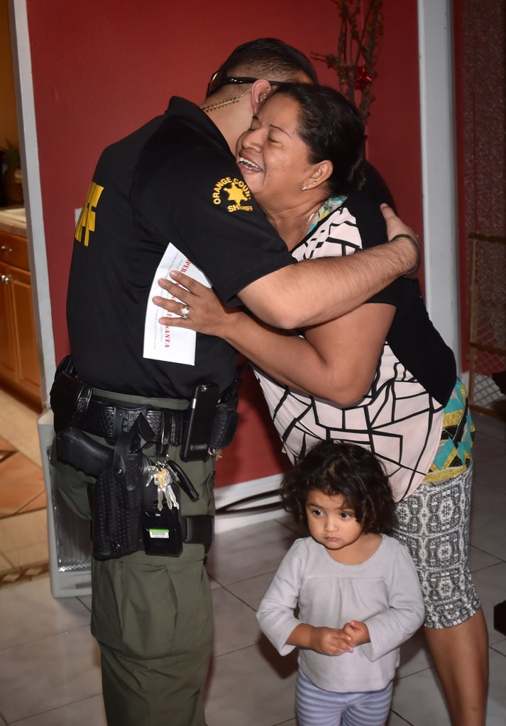 (Carmela Rodriguez ?) gives a hug to OCSD Dep. Anthony Sambrano after receiving a holiday check for $500 as part of Operation Secret Santa which was funded by an anonymous donor. Photo by Steven Georges/Behind the Badge OC