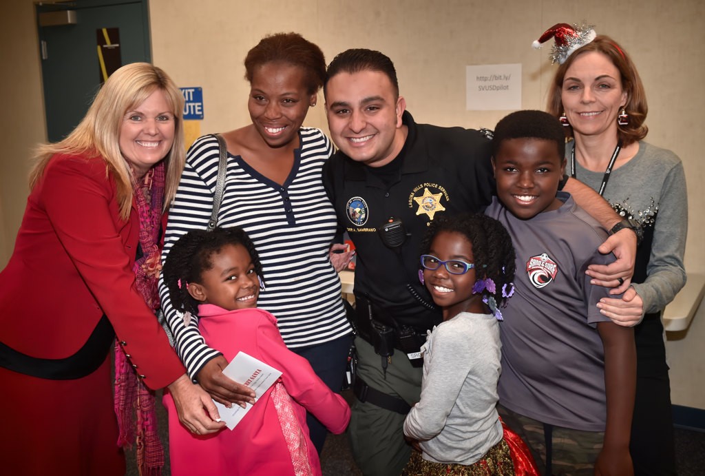 Cameron, a 6th grader at San Joaquin Elementary, with his family, San Joaquin Elementary Principal Karen Schibler, left, OCSD Dep. Anthony Sambrano and TIP volunteer Karolina Lorry, right. Photo by Steven Georges/Behind the Badge OC