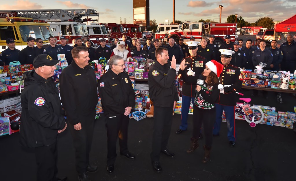 Fire chief’s including Jack Thomas, Orange, left, Tom Schultz, Garden Grove, Randy Bruegman, Anaheim, and Tony Coppolino, Fountain Valley, talk to ABC7 traffic reporter Alysha Del Valle on live television during the Spark of Love Toy Drive. Photo by Steven Georges/Behind the Badge OC