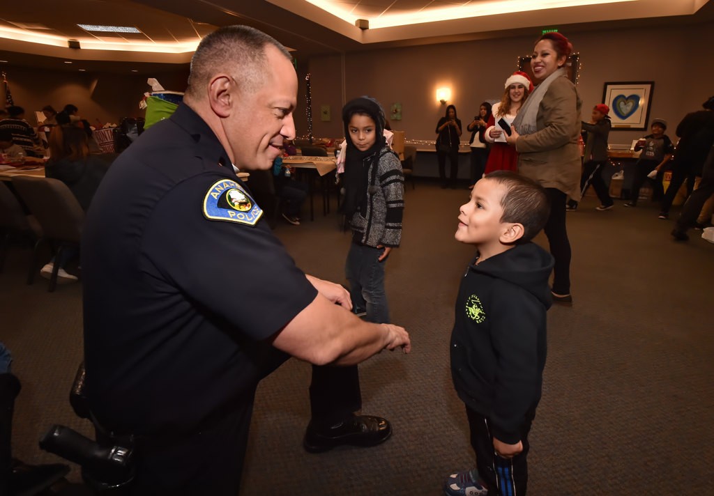 Anaheim Police Chief Raul Quezada talks to a young boy as families gather for OCFJC’s Adopt A Family event. Photo by Steven Georges/Behind the Badge OC