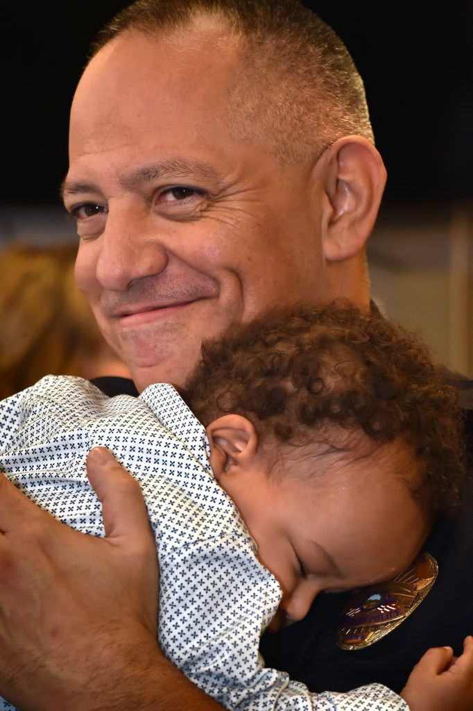 Ten-month-old Mason Phillips finds a warm shoulder on Anaheim Police Chief Raul Quezada. Mason’s mother from Helping Hands Orange County was on hand to visit families they helped during the OCFJC Adopt A Family event. Photo by Steven Georges/Behind the Badge OC
