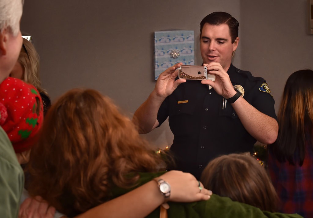 Anaheim PD Officer Bill Segletes helps out taking family photos during OCFJC’s Adopt A Family gathering. Photo by Steven Georges/Behind the Badge OC
