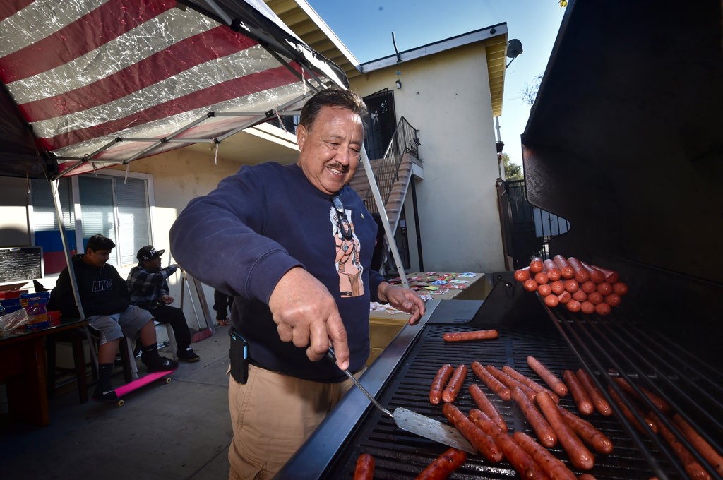 Bob Cardoza cooks a few hot dogs for the  kids in the Palma Vista neighborhood. Photo by Steven Georges/Behind the Badge OC