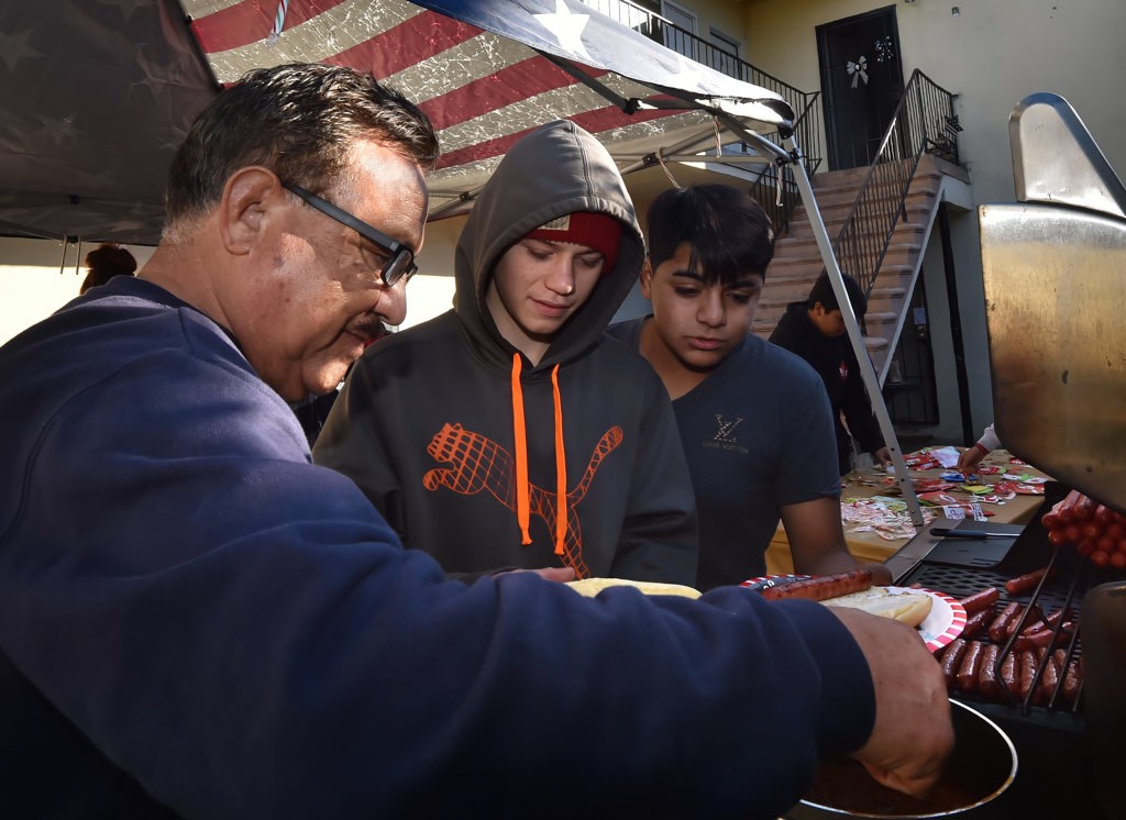 Bob Cardoza, left, serves lunch to kids in the neighborhood. Photo by Steven Georges/Behind the Badge OC