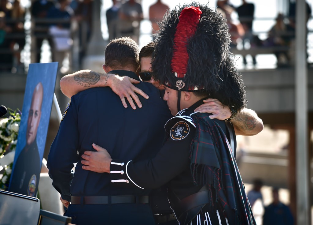 OCFA Capt. Matthew Schuetz talks about his friend and colleague, Capt. Eric Weuve, during a memorial service at Huntington Beach Pier Plaza. Photo by Steven Georges/Behind the Badge OC