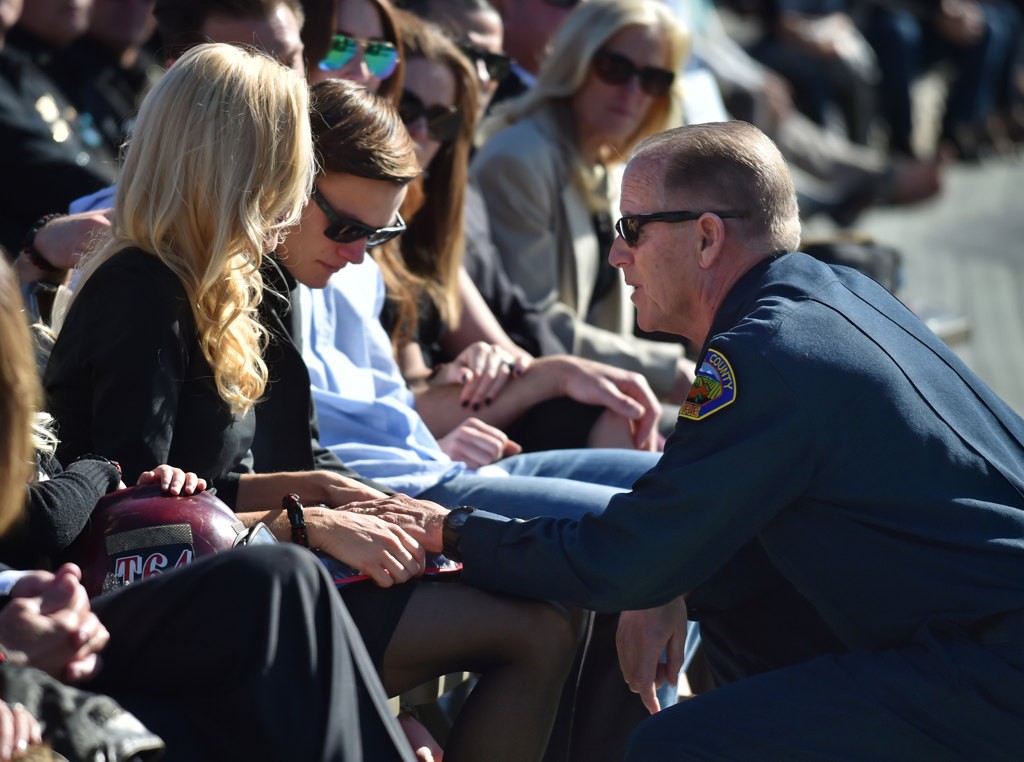 OCFA Fire Chief Jeff Bowman kneels down to console Capt. Eric Weuve’s 14-year-old son, Parker, during a memorial service. Photo by Steven Georges/Behind the Badge OC