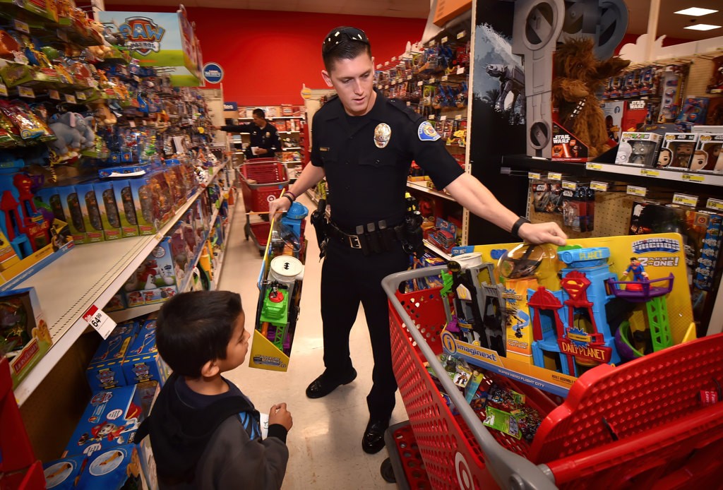 Garden Grove PD Officer John Yergler helps out as 6-year-old Alan Guerra participates in the department’s Shop with a Cop event. Photo by Steven Georges/Behind the Badge OC