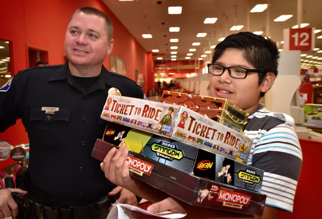 Ten-year-old Leonardo Vonola caries the result of his shopping spree with the help of Garden Grove PD Officer Chuck Starnes during the department’s Shop with a Cop event at Target. Photo by Steven Georges/Behind the Badge OC