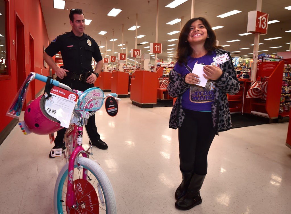 Camila Bello, 8, flashes a big smile after picking out a brand new bicycle at Target during the Garden Grove PD’s Shop with a Cop event. Photo by Steven Georges/Behind the Badge OC