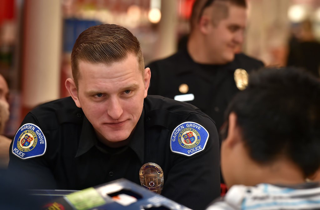 Garden Grove PD Officer Jeremy Morse talks to the kid he partnered with for GGPD’s Shop with a Cop event. Photo by Steven Georges/Behind the Badge OC