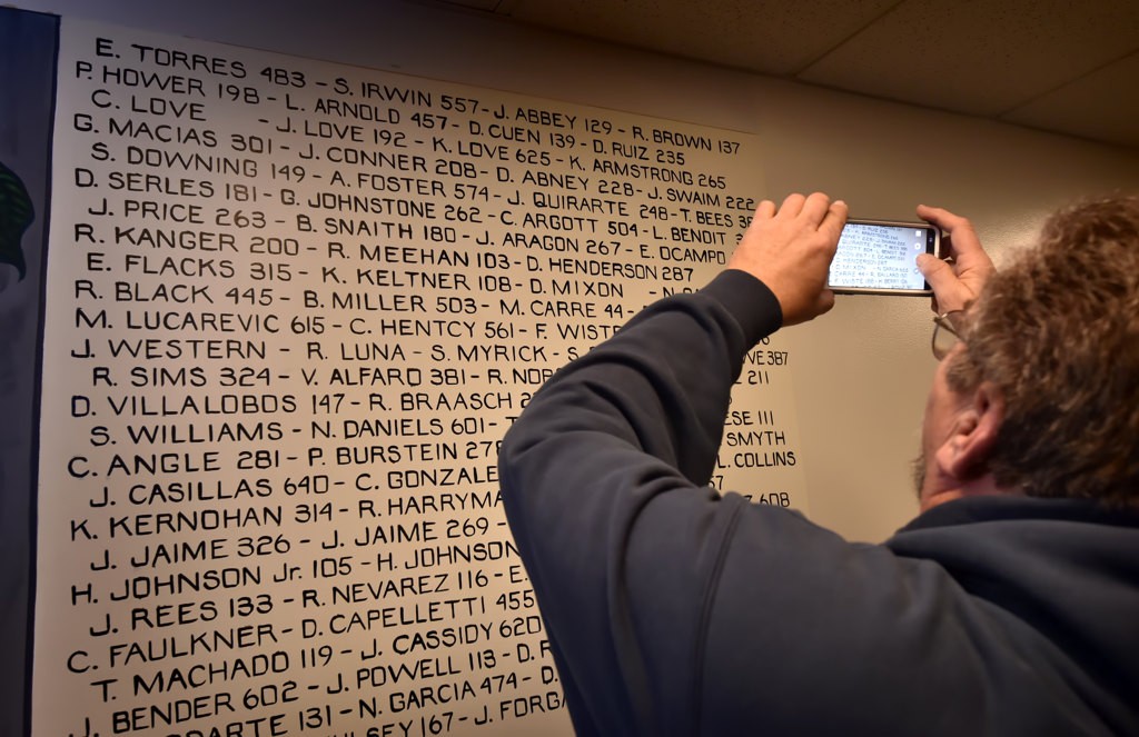 Larry Benoit, a La Habra reserve officer who retired in 2014, photographs the names of his friends, and himself, that is part of the mural unvalued at the La Habra Police Department. Photo by Steven Georges/Behind the Badge OC