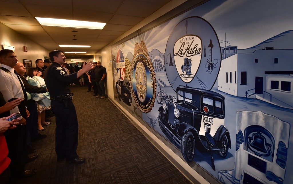 La Habra Police Sgt. Daniel Barnes shows the newly unvalued mural depicting the new and old police department. Photo by Steven Georges/Behind the Badge OC
