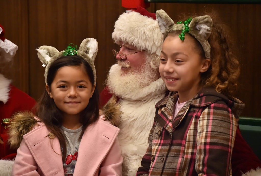Santa visits with each kid during Fullerton PD”s Adopt a Family holiday program at police headquarters. Photo by Steven Georges/Behind the Badge OC