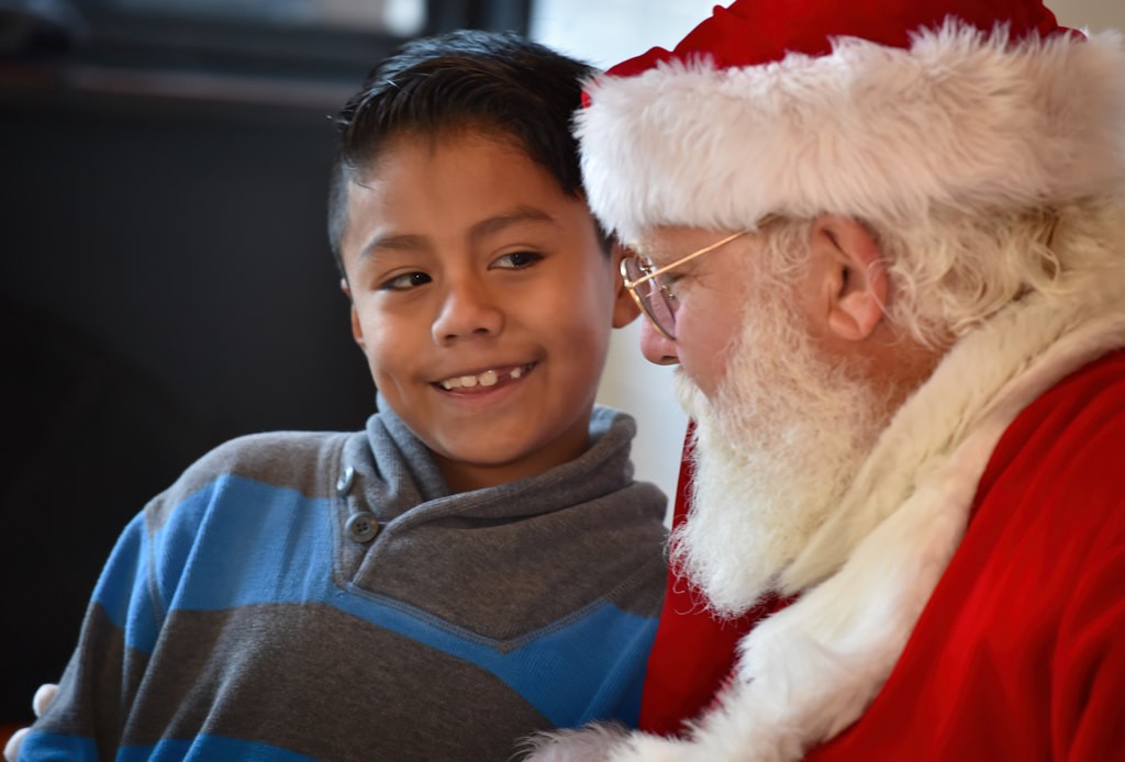 Eight-year-old Ricardo Jijon tells Santa what he wants for Christmas during Anaheim’s Community Holiday Brunch. Photo by Steven Georges/Behind the Badge OC