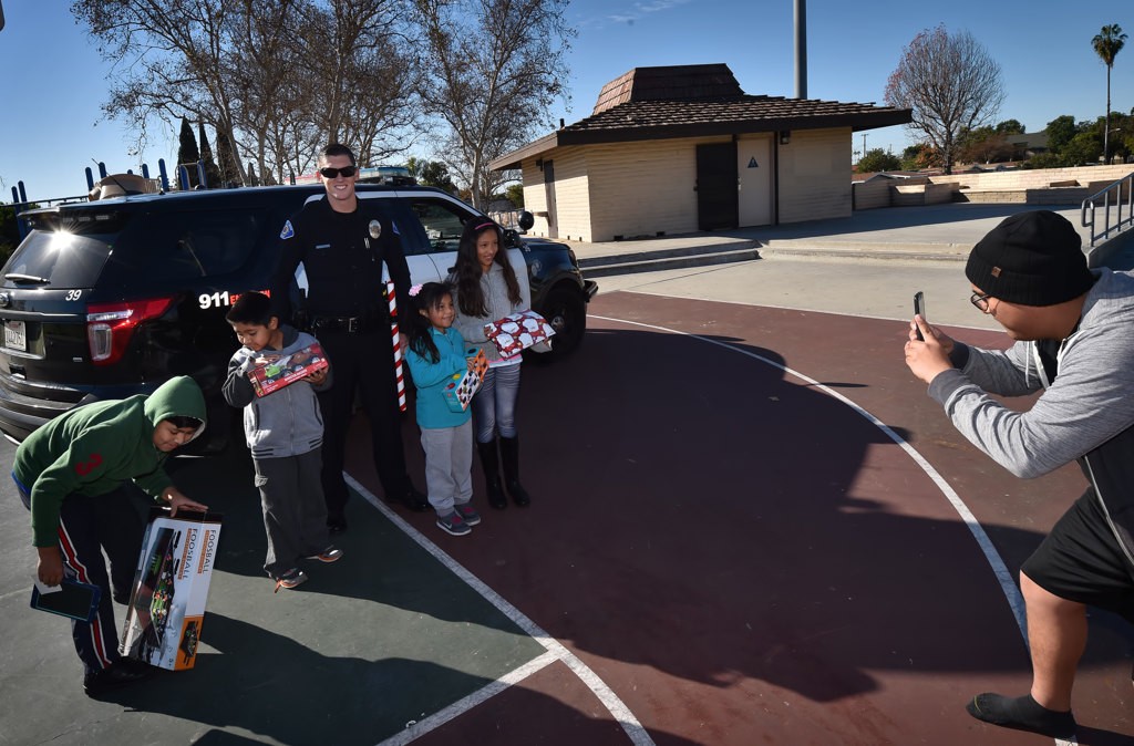 Kids gather as parents take their kids photos with Garden Grove PD Officer John Yergler on Christmas morning. Photo by Steven Georges/Behind the Badge OC