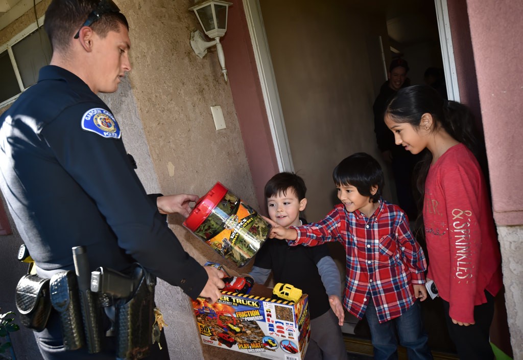 Garden Grove PD Officer John Yergler offers Garden Grove kids their choice of gifts on Christmas morning. Photo by Steven Georges/Behind the Badge OC