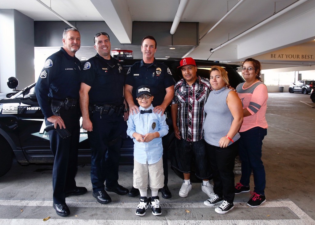 Nine-year-old Mateo Sanchez, center, wished for a pizza party with members of the Westminster Police Department to celebrate his birthday this year. Officers had lunch with him and took him on a tour of the station. Photo by Christine Cotter/Behind the Badge OC. 