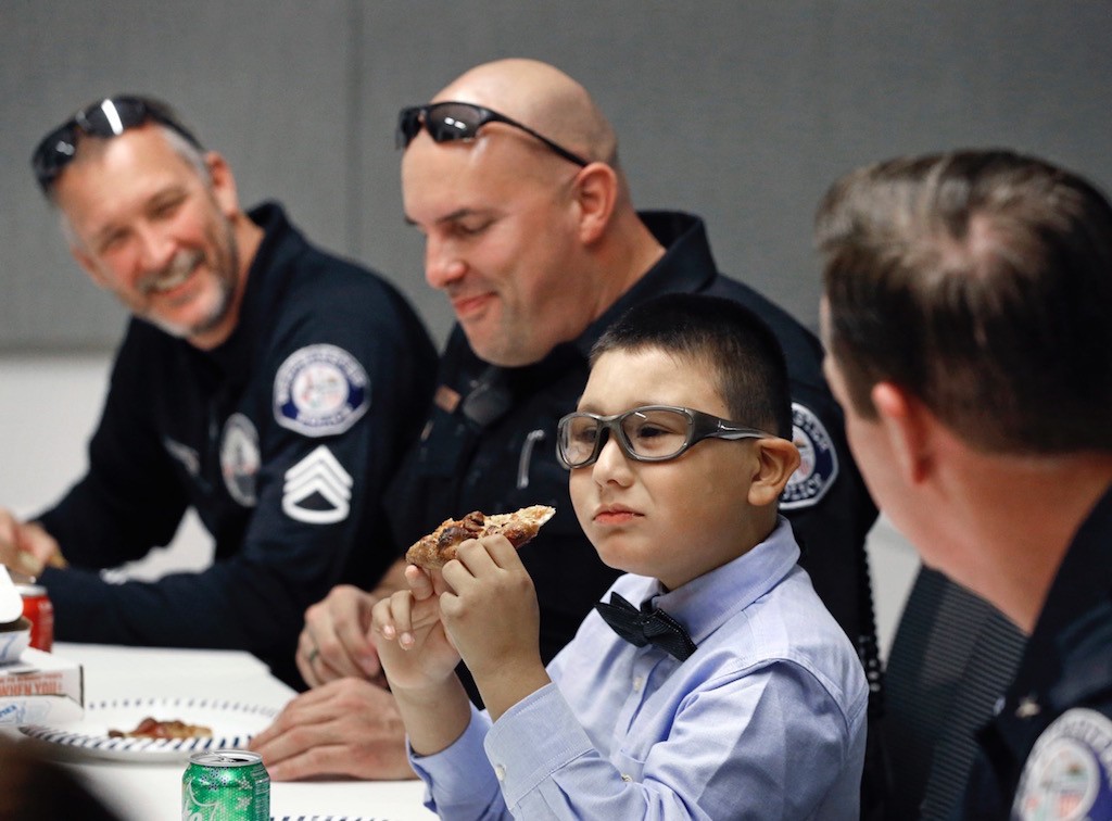 Westminster PD officers chat with 9-year-old Mateo Sanchez over pizza and soda in celebration of Mateo's birthday. Photo by Christine Cotter/Behind the Badge OC. 