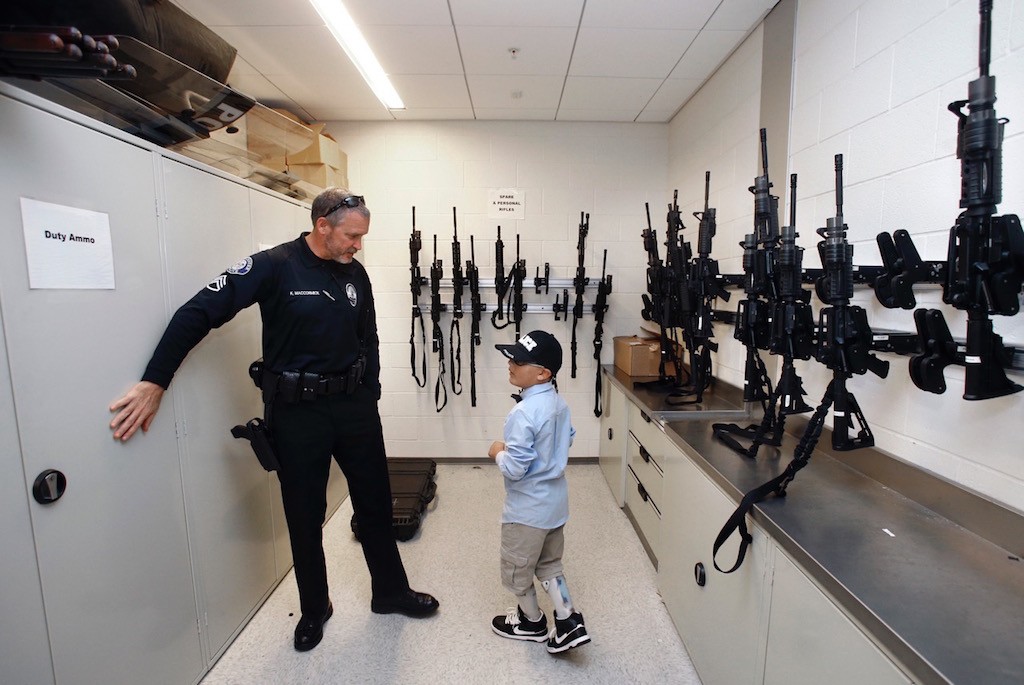 Sgt. Kevin McCormick gives 9-year-old Mateo Sanchez a tour of the Westminster PD's armory. Photo by Christine Cotter/Behind the Badge OC. 