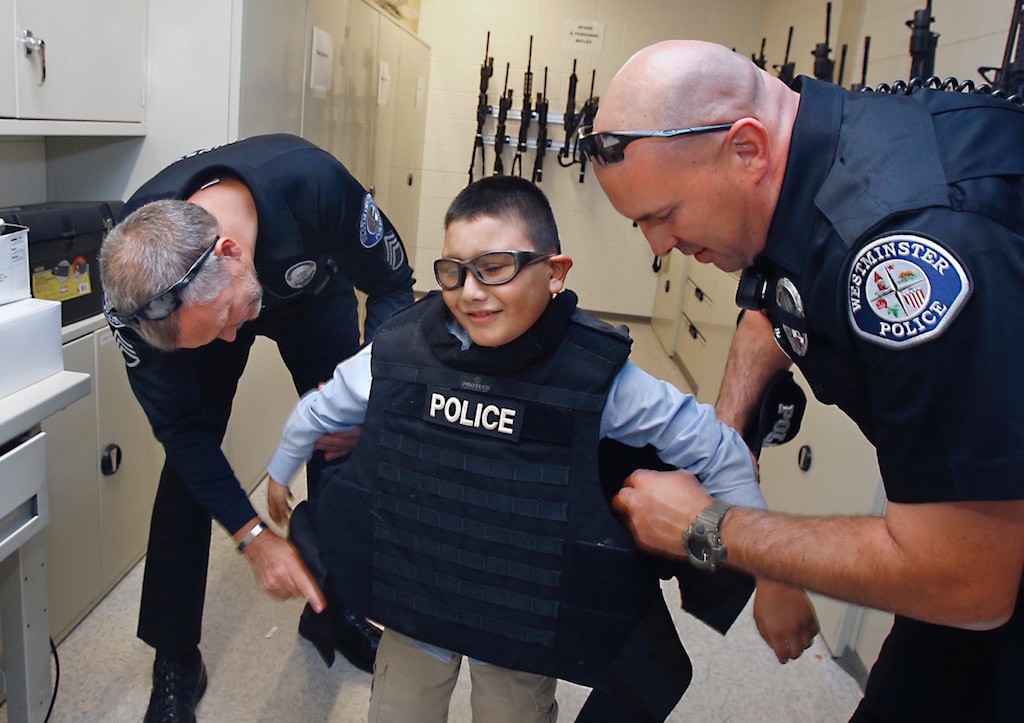 Mateo Sanchez, 9, tried on a bulletproof best inside the Westminster Police Department's armory. Photo by Christine Cotter/Behind the Badge OC. 