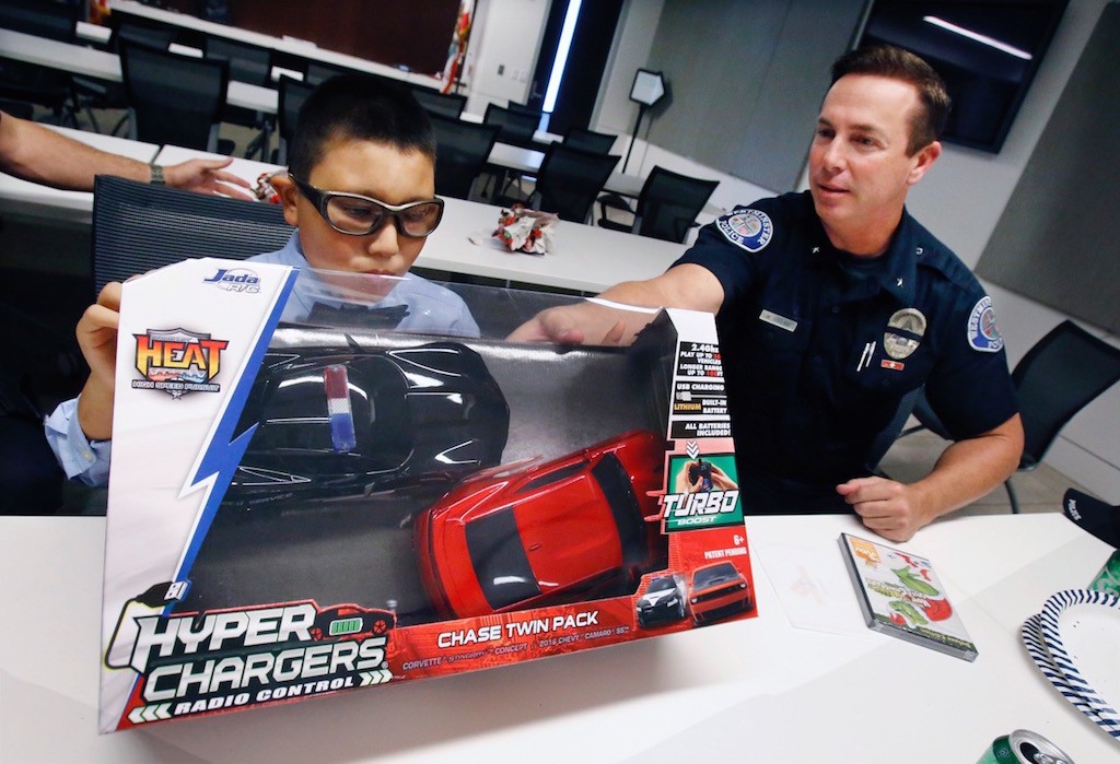 Members of the Westminster Police Department pooled money from their own pockets to buy gifts for Mateo Sanchez's 9th birthday party at the department. The officers bought him "The Grinch Who Stole Christmas" on DVD and a remote-controlled police car. Photo by Christine Cotter/Behind the Badge OC. 