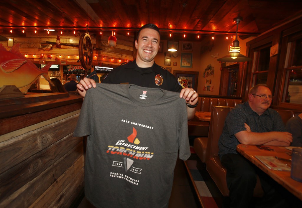 Garden Grove officer Jeremy Morse with a Law  Enforcement Torch Run t-shirt during a fundraiser for the Special Olympics. Photo by Christine Cotter