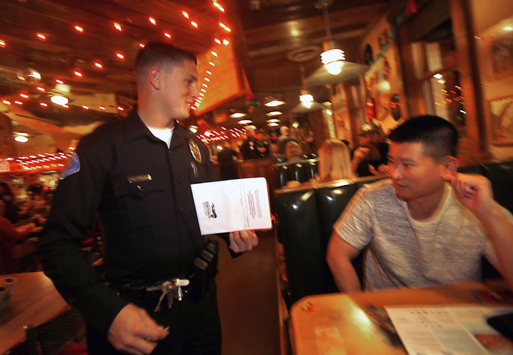 Garden Grover Officer xxx waits tables at Joe's Crab Shack to raise money for the Special Olympics. Photo by Christine Cotter