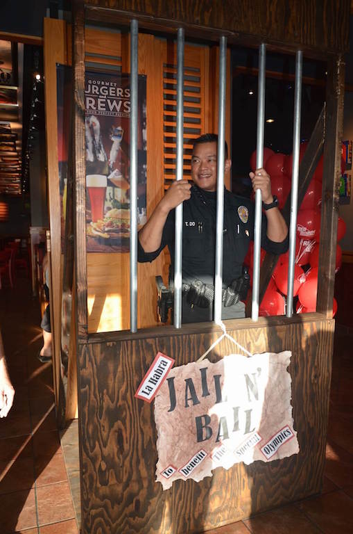 La Habra Motor Officer Tam Do waits behind bars until he can raise enough money for bail as part of a fundraiser at a previous Tip a Cop event. Photo courtesy La Habra PD. 