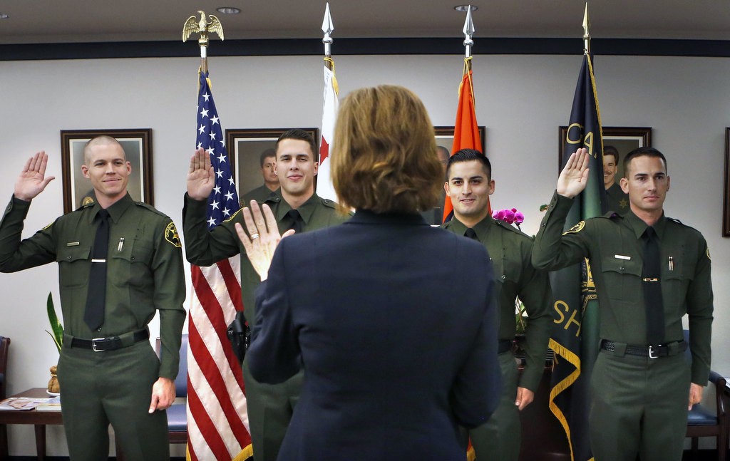 Stephen Essex, John Sands, Steven Salazar and Jared Hendee, from left, during their swearing in ceremony led by Orange County Sheriff Sandra Hutchens.   Photo by Christine Cotter