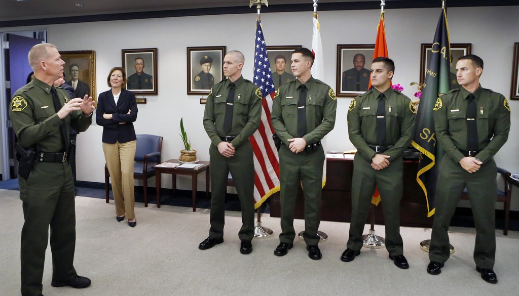 xxx, at left speaks to new Laterals, Stephen Essex, John Sands, Steven Salazar and Jared Hendee, during a swearing in ceremony at the OC Sheriff's Department. Photo by Christine Cotter