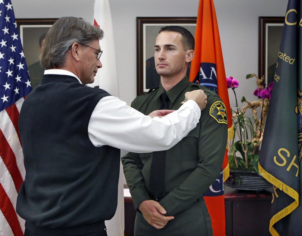 Jared Hendee with his father Dodge during a swearing in ceremony for Laterals at the Orange County Sheriff's Department.  Photo by Christine Cotter