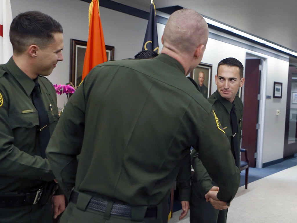 Jared Hendee, right, is congratulated by fellow Laterals after a swearing in ceremony at the Orange County Sheriff's Department.  Photo by Christine Cotter
