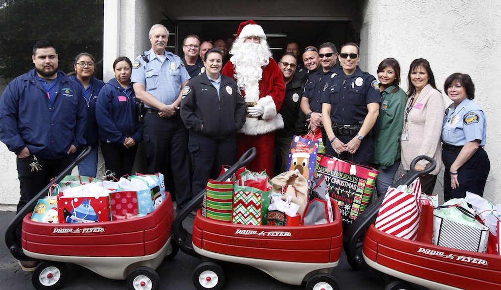 Members of the Tustin Police Department gather for a group photo before delivering Christmas gifts for children hospitalized with brain injuries. Photo by Christine Cotter/Behind the Badge OC