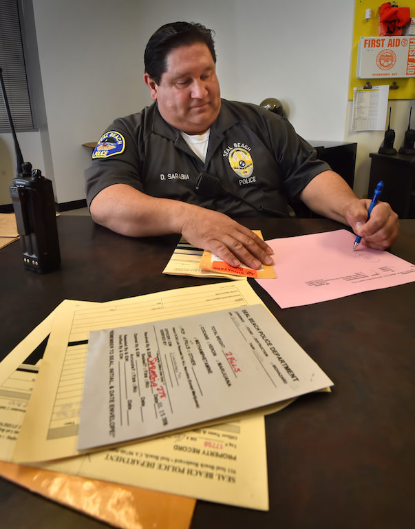 Dominic Sarabia, senior community services officer from the Seal Beach PD, logs in some evidence at the Orange County Sheriff-Coroner Department’s Evidence Control Unit. Photo by Steven Georges/Behind the Badge OC