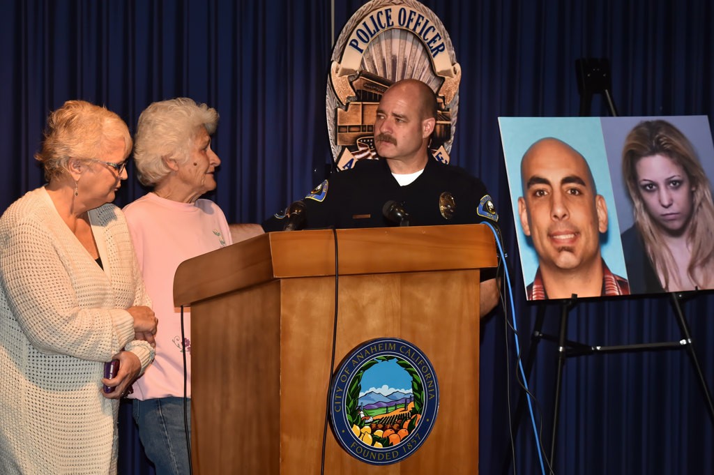 Mary Norris, left, holds onto her best friend, Linda Navarro, mother of murder victim Douglas Navarro, during a press conference with APD’s PIO Sgt. Daron Wyatt, right, asking for the publics help in locating murder suspect Luke Theodore Lampers, photo behind them, and kidnap victim Brianne Deese, photo on far right. Photo by Steven Georges/Behind the Badge OC