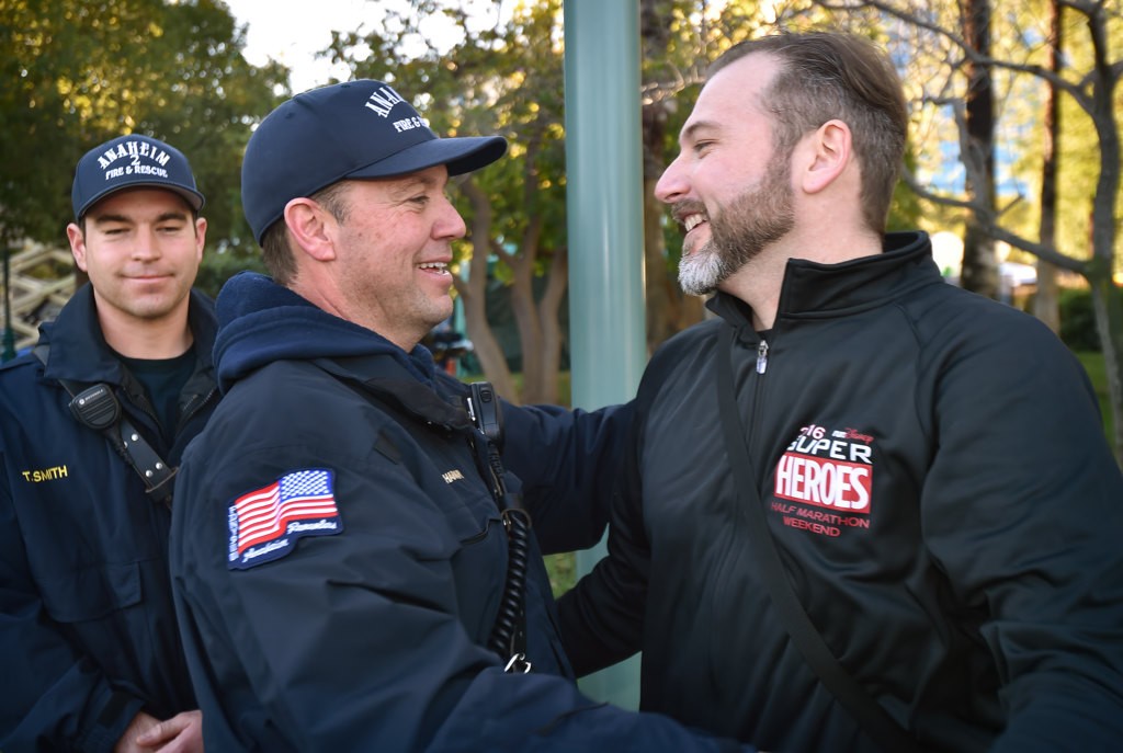 AF&R Jason Buchanan gets a hug from cardiac arrest survivor Jonathan Hika, right, a year after being rescued at the Disneyland run.  Photo by Steven Georges/Behind the Badge OC