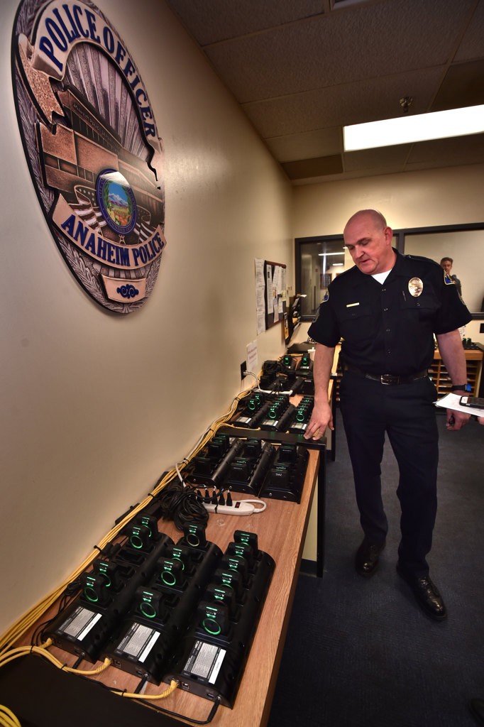 Sgt. Garet Bonham shows the docking bays where body cameras are charges while automatically downloading the data to APD servers. Photo by Steven Georges/Behind the Badge OC