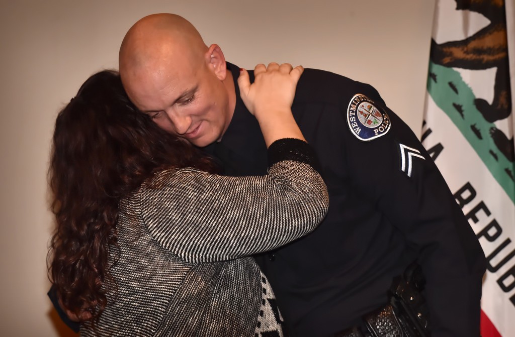 Cpl. Jeremy Fletcher gets a hug from his wife, Adriana Fletcher, after pinning his new badge on him. Photo by Steven Georges/Behind the Badge OC