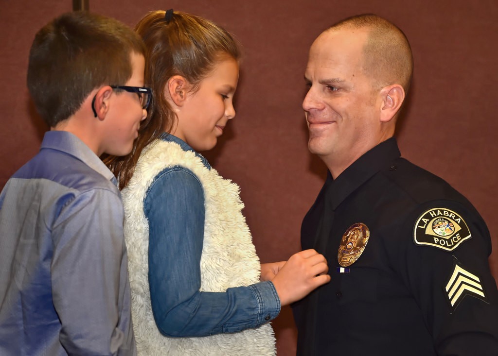 Sgt. Eric Ocampo has his new badge pinned to him by his kids, Jake, 10, and Emmy, 8, during LHPD’s promotion ceremony. Photo by Steven Georges/Behind the Badge OC