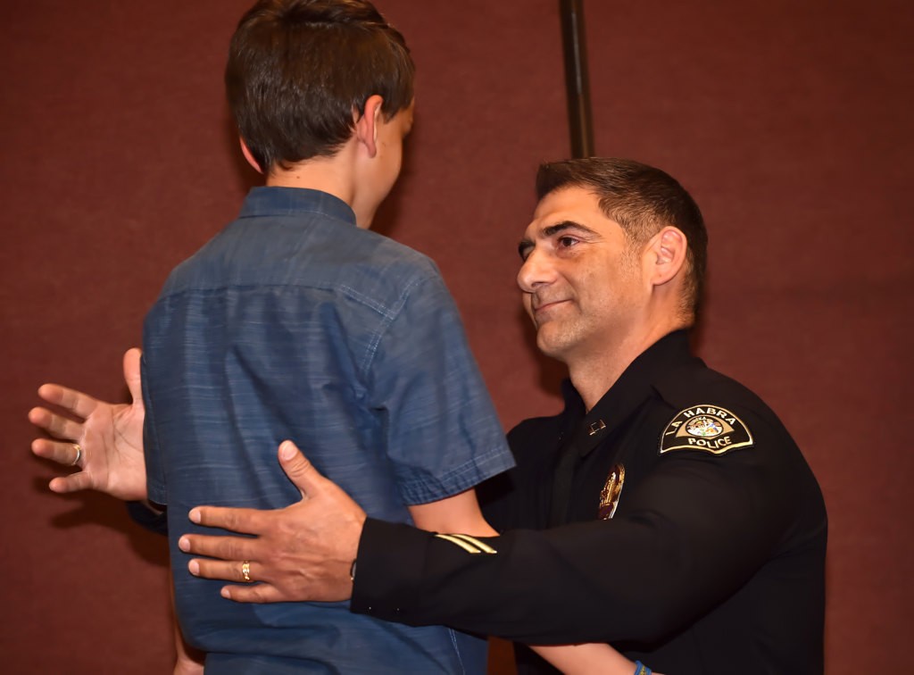 Capt. Dean Capelletti gets a hug from his son, Nikolas Capelletti, 10, after receiving his new captains badge during LHPD’s promotion ceremony. Photo by Steven Georges/Behind the Badge OC